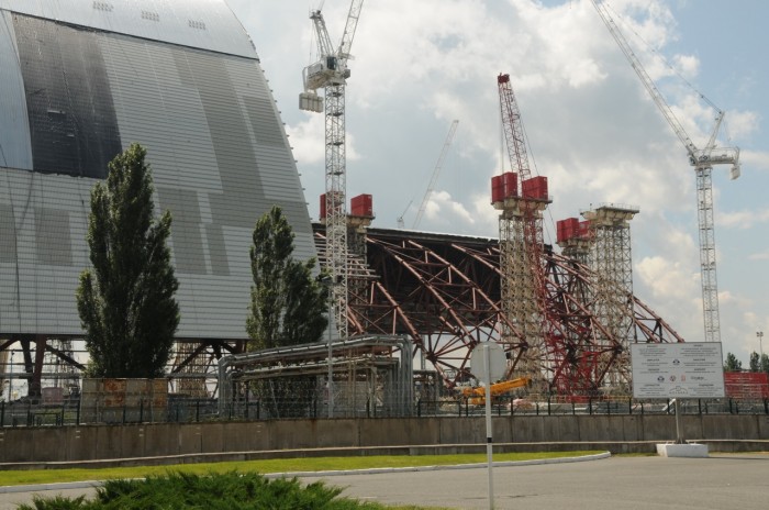 A quelques dizaines de mètres du réacteur, on construit un immense hangar de confinement qui sera déplacé sur rail pour couvrir le réacteur. Ce projet gigantesque a été confié à deux sociétés françaises : Vinci et Bouygues.