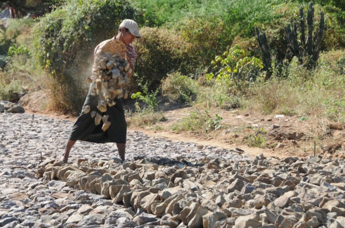 Une scène d’une autre époque: les pierres pour une route sont transportées par panier.